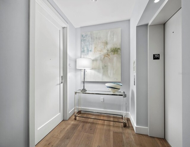 corridor with hardwood / wood-style flooring and elevator