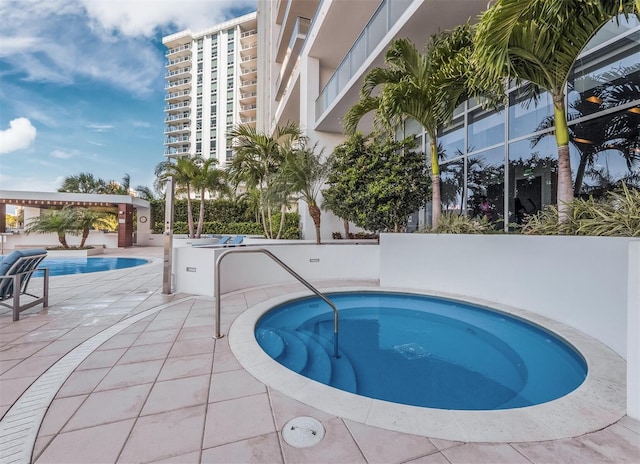 view of pool with a community hot tub and a patio