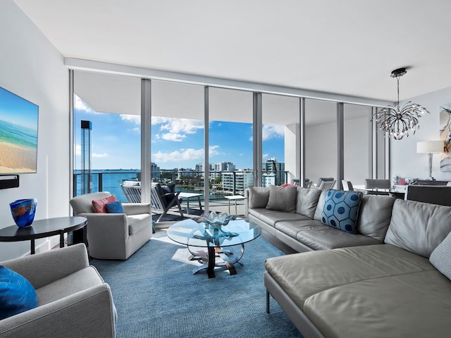 living room featuring a water view, a chandelier, and a wall of windows