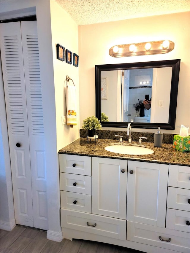 bathroom featuring vanity, a textured ceiling, and hardwood / wood-style flooring