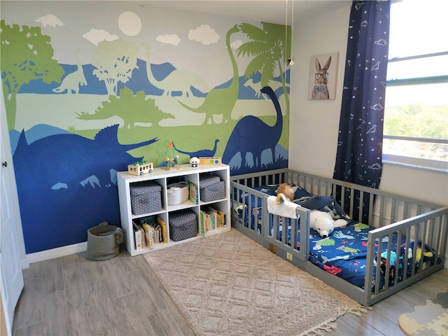 bedroom featuring a crib and hardwood / wood-style flooring