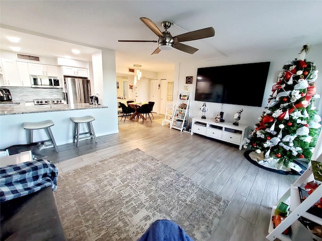 living room with ceiling fan and light hardwood / wood-style floors