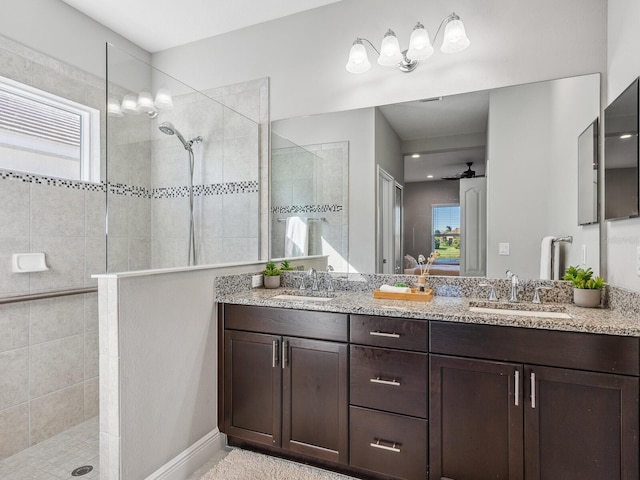 bathroom with vanity, ceiling fan, and a tile shower