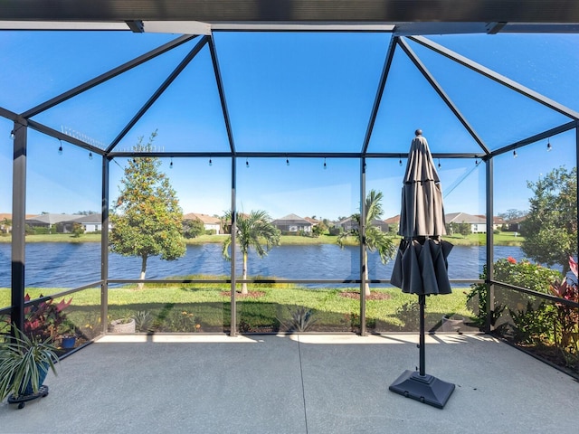 view of patio / terrace with a lanai and a water view