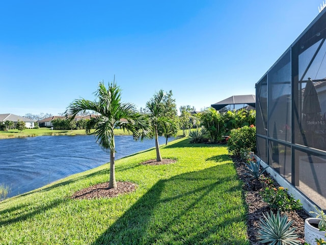 view of yard with glass enclosure and a water view