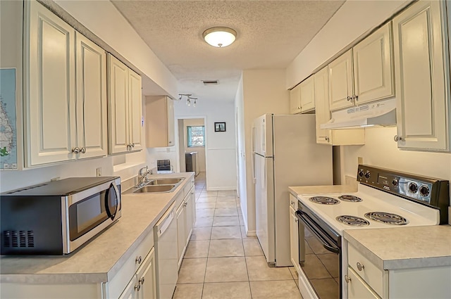 kitchen featuring sink, light tile patterned floors, a textured ceiling, white appliances, and white cabinets