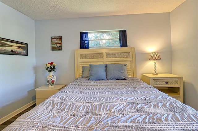 bedroom with a textured ceiling and hardwood / wood-style flooring