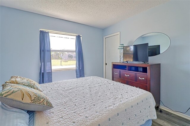 bedroom with hardwood / wood-style floors and a textured ceiling