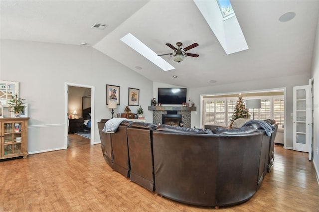 living room featuring ceiling fan, light hardwood / wood-style floors, and lofted ceiling