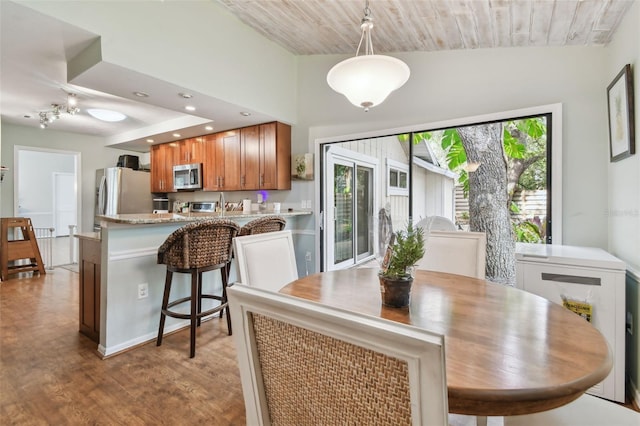 dining area with light hardwood / wood-style flooring, wooden ceiling, and lofted ceiling