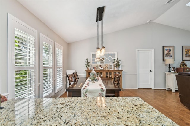 dining area with hardwood / wood-style floors and vaulted ceiling