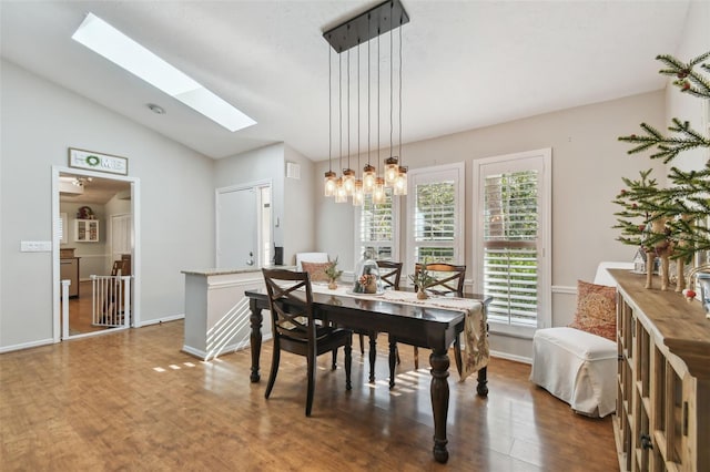 dining room with dark hardwood / wood-style flooring and lofted ceiling with skylight