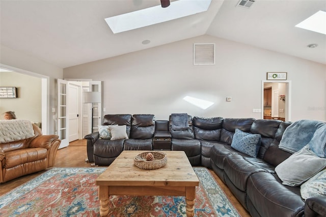 living room featuring ceiling fan and lofted ceiling with skylight