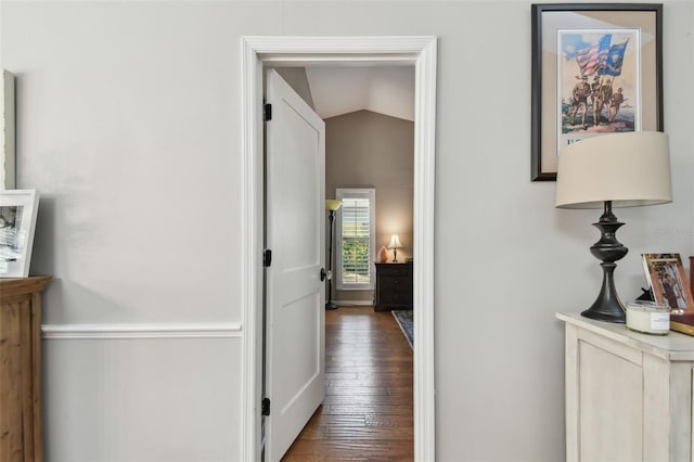 hall featuring dark hardwood / wood-style floors and vaulted ceiling