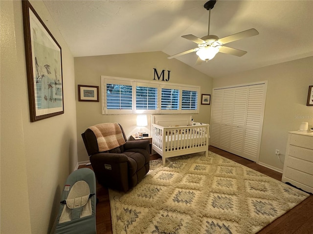 bedroom featuring vaulted ceiling, ceiling fan, a nursery area, wood-type flooring, and a closet