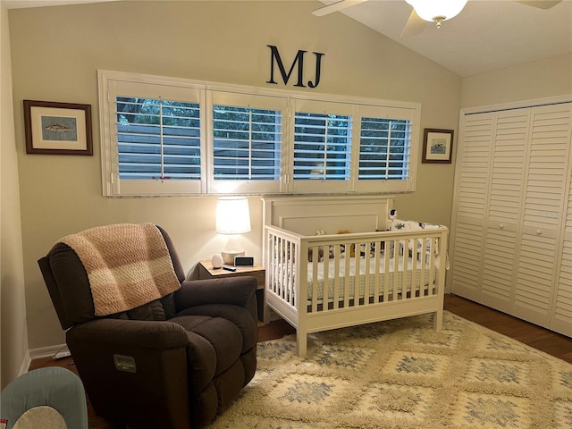 bedroom featuring vaulted ceiling, ceiling fan, hardwood / wood-style flooring, a nursery area, and a closet