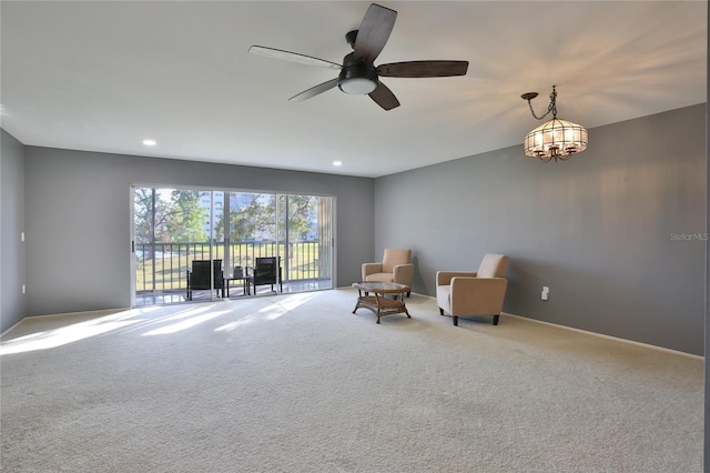 living area with carpet flooring and ceiling fan with notable chandelier