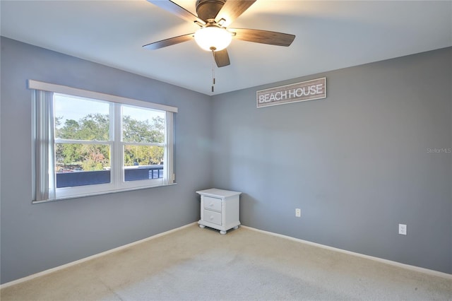 carpeted spare room with ceiling fan