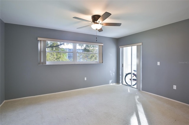 carpeted empty room featuring ceiling fan