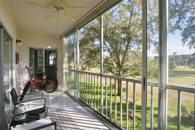 sunroom featuring ceiling fan and plenty of natural light