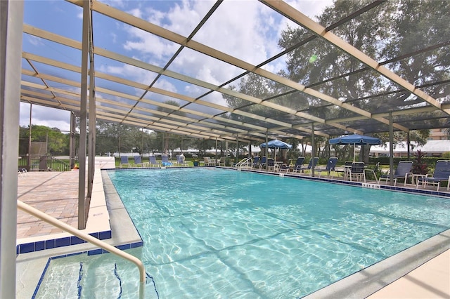 view of pool with a patio area and a lanai