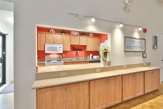 kitchen with white appliances, light parquet floors, and sink