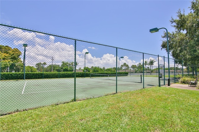 view of sport court featuring a lawn