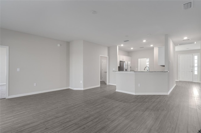 unfurnished living room with hardwood / wood-style flooring and sink