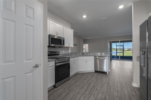 kitchen featuring kitchen peninsula, sink, white cabinets, and stainless steel appliances