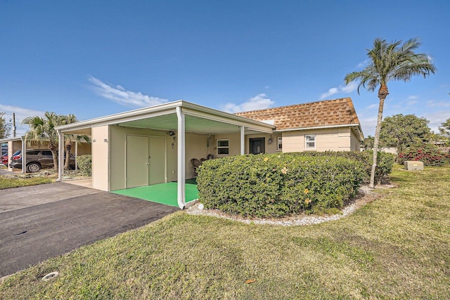 view of side of property featuring a carport and a lawn