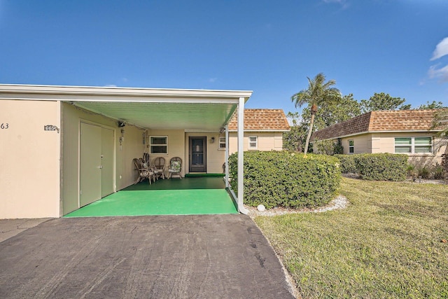 exterior space featuring a front lawn and a carport