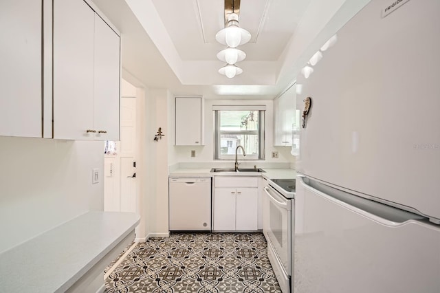 kitchen featuring white cabinets, a raised ceiling, white appliances, and sink