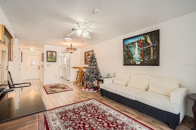 665 Park Cir Unit 58, Bradenton, FL 34207 - living area with wood finished floors, ceiling fan, and a textured ceiling