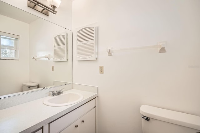 bathroom with vanity, toilet, and radiator heating unit