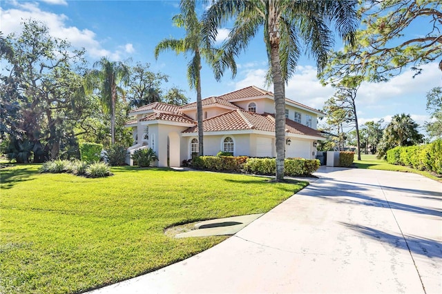 mediterranean / spanish-style house featuring a garage and a front yard