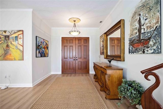 entryway with light hardwood / wood-style flooring and crown molding