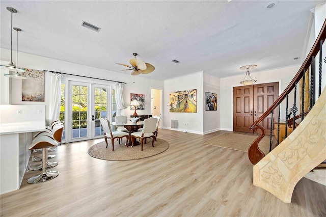 dining space with ceiling fan, french doors, and light wood-type flooring