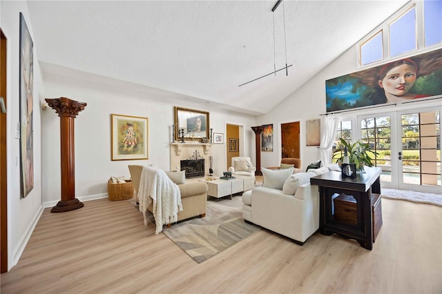 living room featuring decorative columns, french doors, high vaulted ceiling, and light hardwood / wood-style flooring