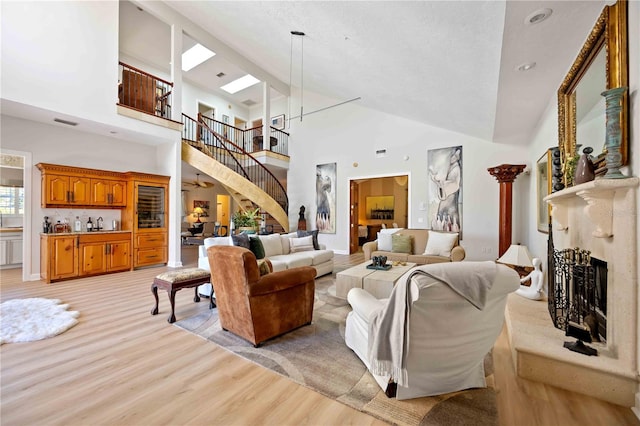 living room with ceiling fan, light hardwood / wood-style flooring, and high vaulted ceiling