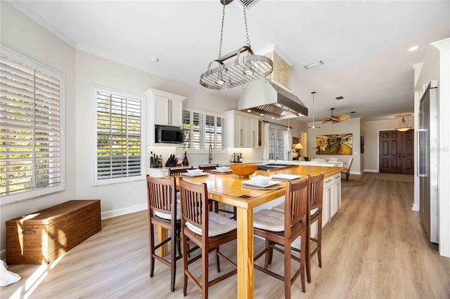 dining room featuring light wood-type flooring, ceiling fan, and sink