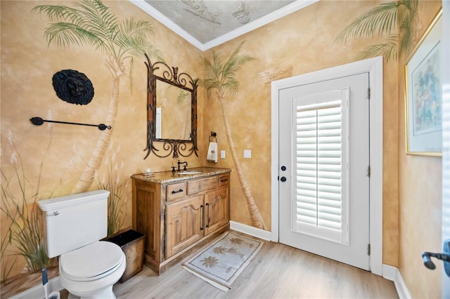 bathroom with crown molding, toilet, vanity, and hardwood / wood-style flooring