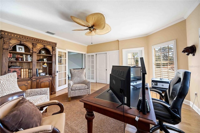 office space featuring ceiling fan, light wood-type flooring, crown molding, and french doors