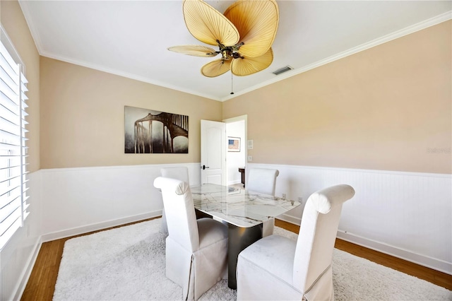 dining space with ceiling fan, wood-type flooring, and crown molding