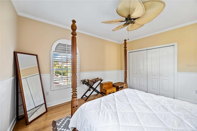 bedroom featuring a closet, light hardwood / wood-style flooring, ceiling fan, and crown molding