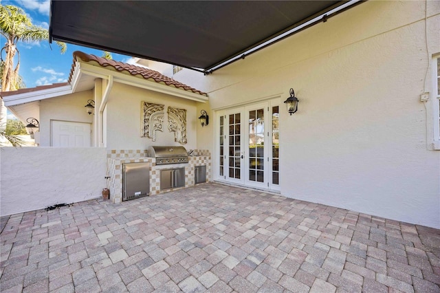 view of patio with an outdoor kitchen, a grill, and french doors