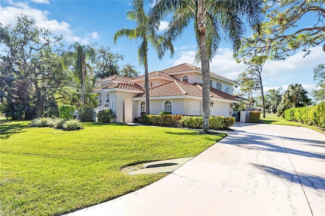 mediterranean / spanish house featuring a garage and a front lawn