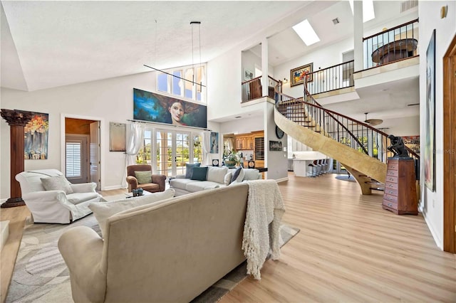 living room featuring french doors, high vaulted ceiling, and light wood-type flooring