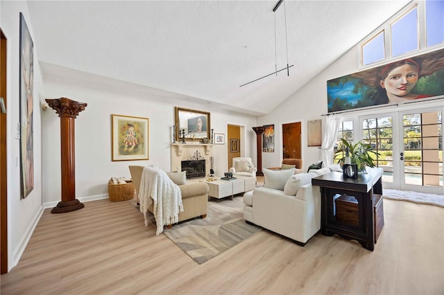 living room with ornate columns, high vaulted ceiling, light hardwood / wood-style floors, and french doors