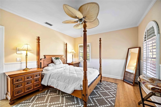 bedroom featuring ceiling fan, ornamental molding, and wood-type flooring