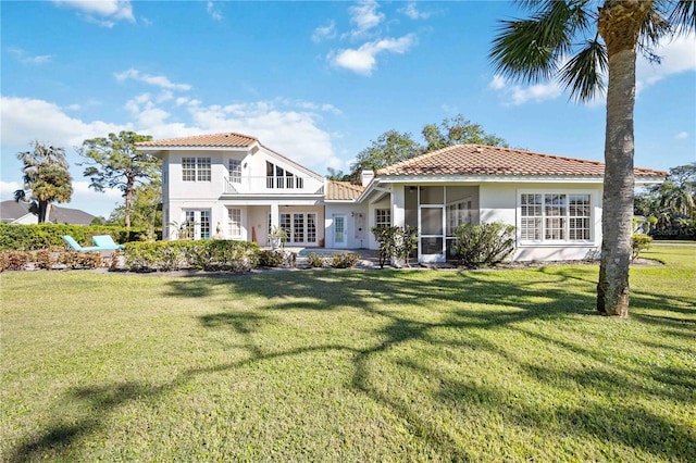 back of house with a sunroom and a lawn